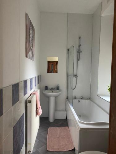 a bathroom with a sink and a tub and a toilet at Castle Gate Apartment in Jedburgh