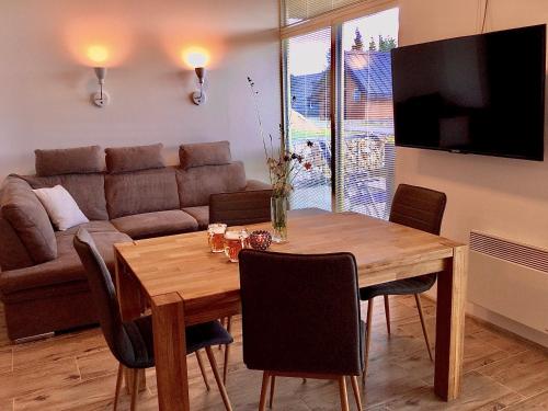 sala de estar con mesa de madera y sofá en Apartmán Horní Mísečky 437, en Horní Mísečky