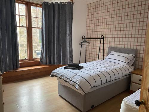 1 dormitorio con 1 cama con lámpara. en Castle Gate Apartment en Jedburgh