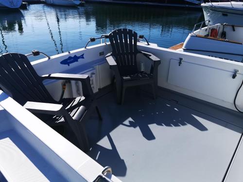 deux chaises assises à l'arrière d'un bateau dans l'établissement Nuit insolite sur un bateau chauffé, à Calais
