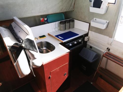 uma pequena cozinha com um lavatório e um fogão em Nuit insolite sur un bateau chauffé em Calais