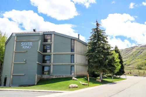 a gray building with a tree in front of it at Silver King by All Seasons Resort Lodging in Park City