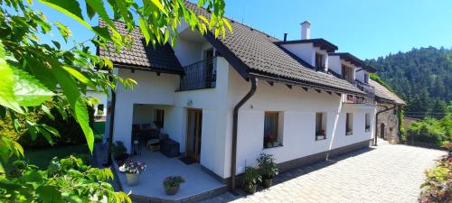 a large white house with a courtyard at Privát Kompišovci in Liptovský Ján