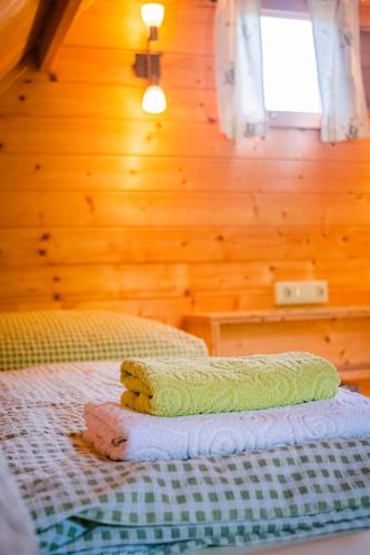 a bed in a room with a wooden wall at Radlerstation-Sandhof in Berg im Drautal