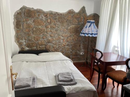 ein Schlafzimmer mit einem Bett mit einer Steinwand in der Unterkunft Villa Ella in Opatija