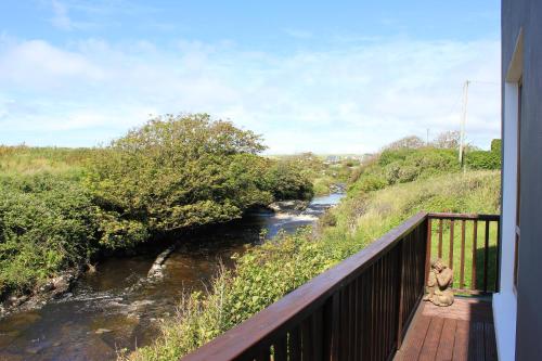 a bridge over a river with two teddy bears on a balcony at Riverbank Rooms in Doolin