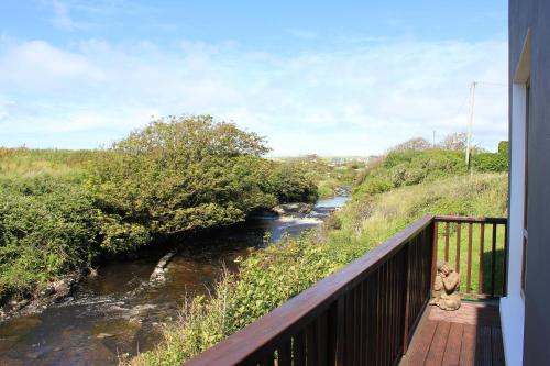 a bridge over a river with two teddy bears on a balcony at Riverbank Rooms in Doolin