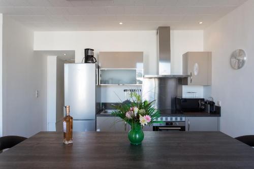 une cuisine avec une table avec un vase de fleurs dessus dans l'établissement COTE PORT, à Cannes