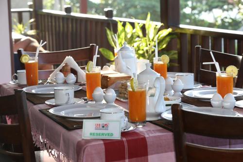 a table with plates and cups and orange juice on it at Seafood Restaurant and Motel in Tangalle