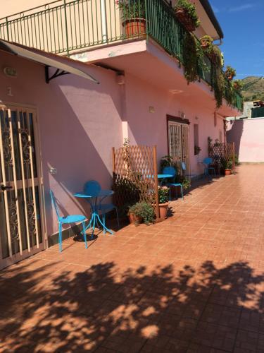 a building with chairs and a table and a balcony at B&B Teodora in Gaggi