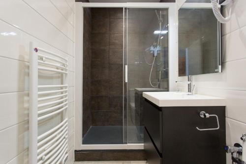 bagno con doccia, lavandino e specchio di COTE PORT a Cannes