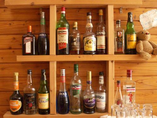 a shelf filled with lots of bottles of alcohol at Kussharo Genya Youth Guesthouse in Teshikaga
