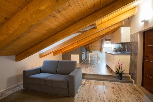 a living room with a couch and wooden ceilings at Vincafè in Alba