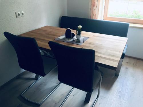 a dining room table with chairs and a wooden table at Ferienwohnung Rottensteiner Sybille inclusiv Sommercard in Jerzens