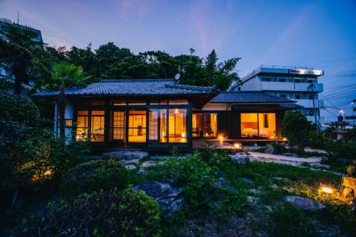 a small house with lights in front of a building at Ajina House - Vacation STAY 84934 in Hatsukaichi