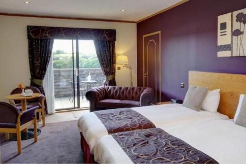 a hotel room with a bed and a balcony at Passage House Hotel in Newton Abbot