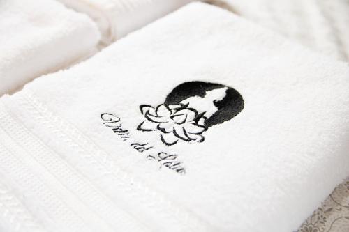 a white towel with a flower on it at Pousada Villa del Lótus in Itarema