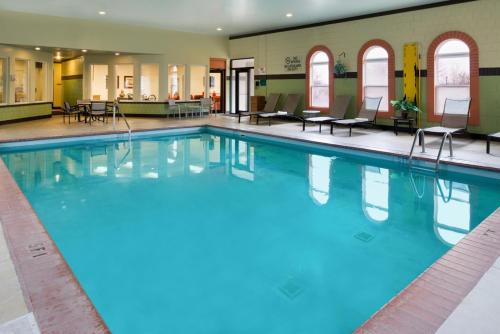 a large swimming pool with blue water in a building at Charwood Suites in Columbus
