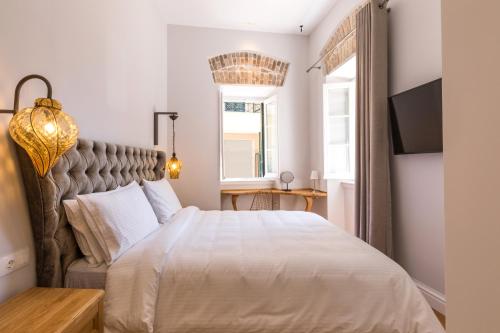 a bedroom with a large bed and a window at Acanthus blue in Corfu Town