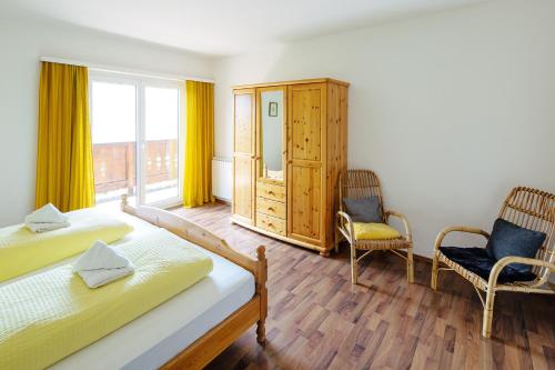 a bedroom with two beds and two chairs and a window at Haus Tomas in Radstadt