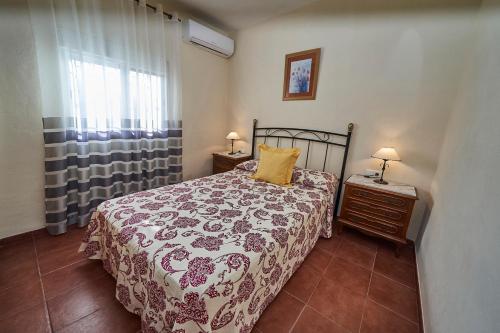 a bedroom with a bed and a dresser and a window at Casa Rural Mi Cortijo in Nerja