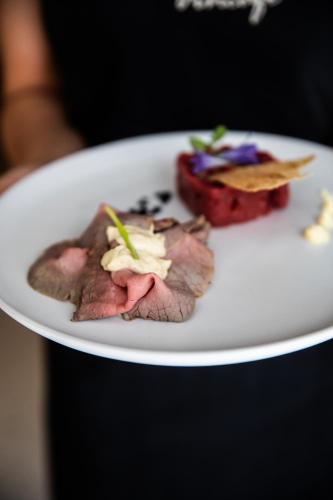 a plate of food with meat and vegetables on it at Vincafè in Alba