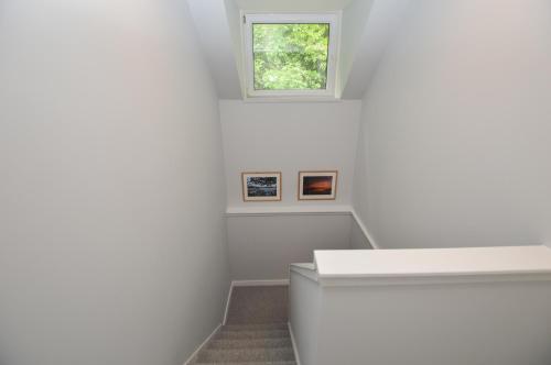 a white staircase in a white room with a window at Fairhaven, Oban Town Centre in Oban