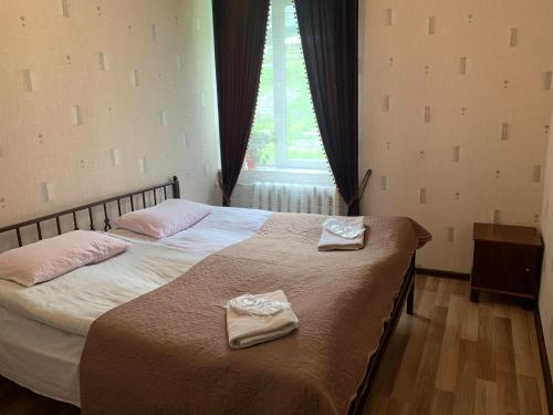 a bedroom with a bed with two towels on it at Panorama Kazbegi in Stepantsminda