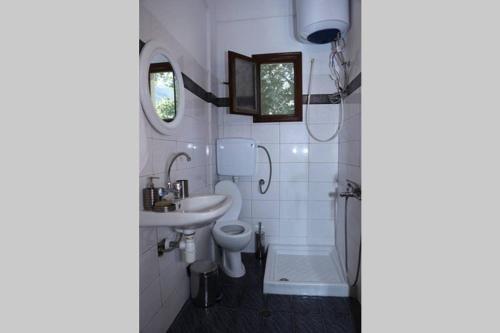 a bathroom with a toilet and a sink and a tub at Casa Lanardi, Stavros in Stavros