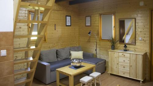 ein Wohnzimmer mit einer Couch und einem Tisch in der Unterkunft Robinzonski smještaj Green Peak in Tuhelj