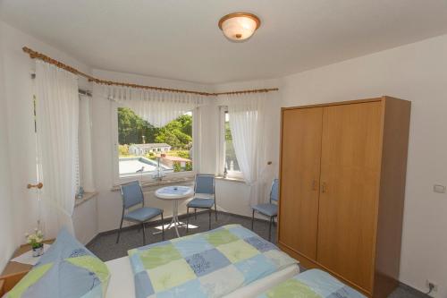 een slaapkamer met een bed, een tafel en stoelen bij Ferienwohnungen Beyer in Binz