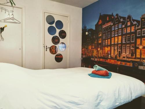 a bedroom with a white bed with a painting on the wall at H 58 in Amsterdam