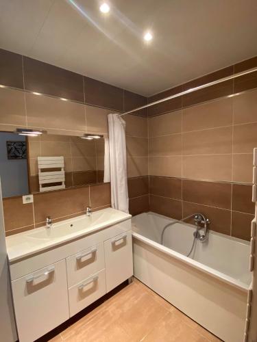 une salle de bain avec une baignoire et un lavabo et une baignoire dans l'établissement Le Jardin Minelle, à Arras