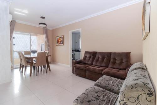 a living room with a couch and a table at APARTAMENTO VISTA MAR - Pé na areia in Balneário Camboriú