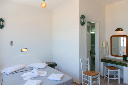 a bedroom with a bed and a sink and a mirror at Almyra Seaside Suites in Platis Gialos