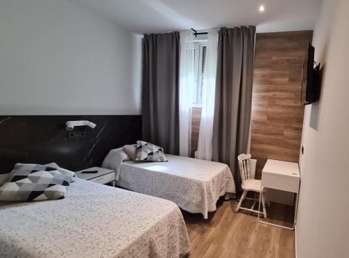 a small bedroom with two beds and a window at Asieran in Amorebieta-Etxano