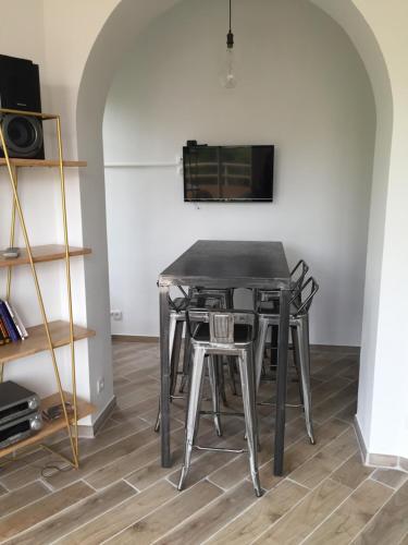 une table à manger avec des chaises et une télévision murale dans l'établissement Centre ville Perpignan - Le Castillet, à Perpignan