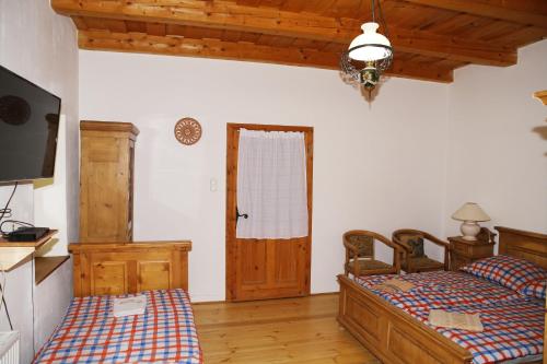 a bedroom with two twin beds and a television at Tanya Üdülőház in Garáb