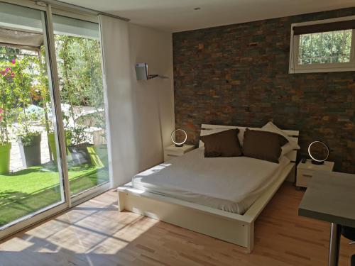 um quarto com uma cama e uma parede de tijolos em Lou Pauseto em Aubagne