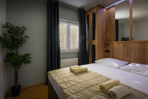 1 dormitorio con 1 cama con 2 toallas en Apartments Blatančić, en Vodice