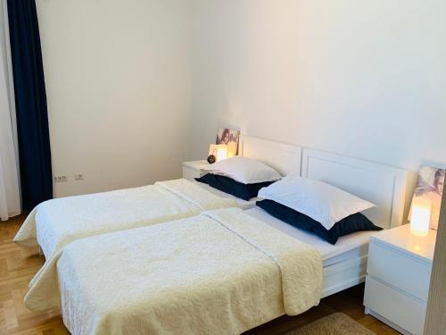 een slaapkamer met 2 bedden met witte lakens en kussens bij Lavender Bay Apartment B13 in Donji Morinj