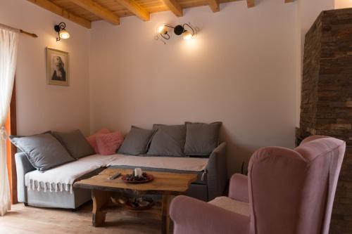 a living room with a couch and a table at Planinska kuca Popovic 3 in Ljuboš