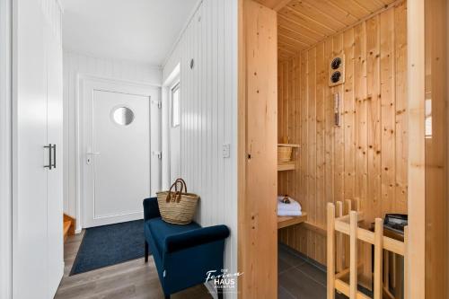 a room with a blue chair and wooden walls at Beluga in Olpenitz