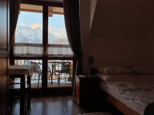 a bedroom with a large window with a view of mountains at Pokoje Widokowe Szymaszkowa in Zakopane