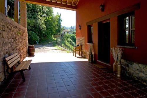 a porch of a house with a bench and a building at La Llosa de Repelao in Covadonga