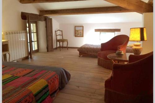 una camera con letto, divano e sedia di Secluded South of France stone mas built 1833 4 bedroom a Saint-André-dʼOlérargues
