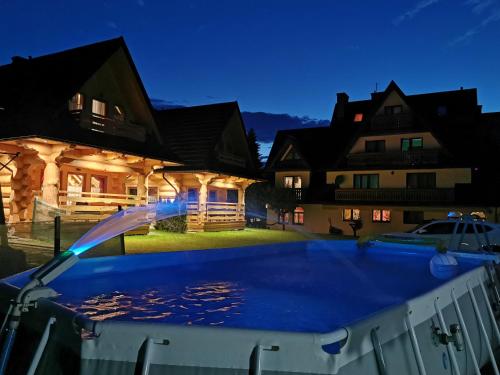 a pool in front of a house at night at Janulkowe Domki in Zakopane