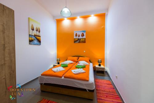 sypialnia z pomarańczowym łóżkiem w pokoju w obiekcie Downtown Lux Apartments, Subotica w mieście Subotica