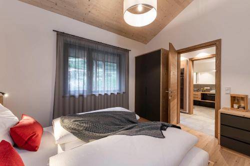 a bedroom with a white bed and a window at Ölackererhof in Bressanone