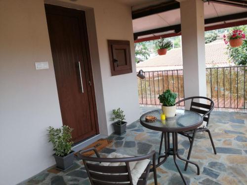 eine Terrasse mit einem Tisch und Stühlen sowie einem Balkon in der Unterkunft Melina's Studios in Argalasti